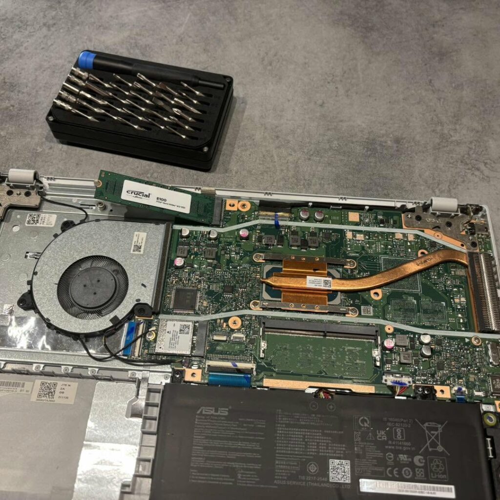 Intérieur d'un PC portable Asus ouvert : ventilateur, caloducs, SSD et RAM